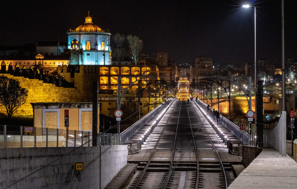 Railway tracks across an illuminated bridge at night