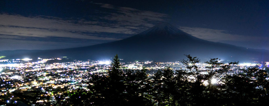 Mountain silhouette above city lights at night